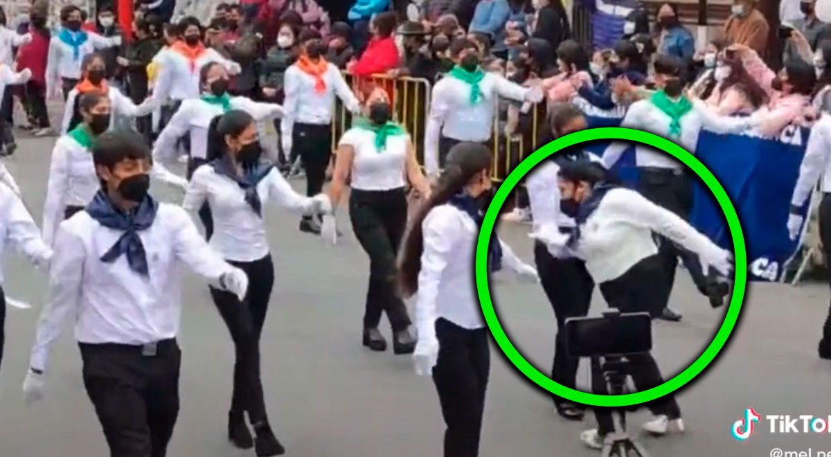 Young person leads civic parade but has an awkward moment by tripping.